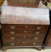 A George III walnut bureau with a sloping fall enclosing a fitted interior above four long