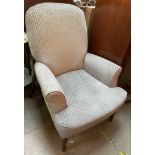 A Victorian style nursing chair with an upholstered back and seat on turned legs