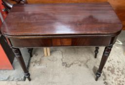 A 19th century mahogany tea table with a rectangular foldover top on ring turned legs