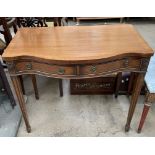 A reproduction mahogany side table with a serpentine top above two drawers on square tapering legs