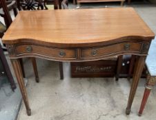 A reproduction mahogany side table with a serpentine top above two drawers on square tapering legs