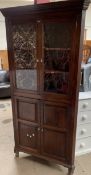 A 19th century oak standing corner cupboard, the moulded cornice above a pair of glazed doors,