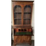 A reproduction mahogany secretaire bookcase with a pair of glazed doors the base with a secretaire