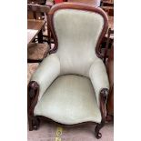 A Victorian mahogany framed spoon back gentleman's chair with a pad upholstered back and seat on
