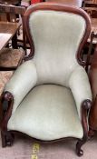 A Victorian mahogany framed spoon back gentleman's chair with a pad upholstered back and seat on