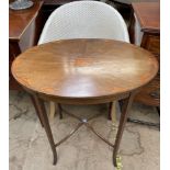 An Edwardian mahogany occasional table with an oval top on square tapering legs,