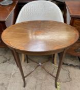 An Edwardian mahogany occasional table with an oval top on square tapering legs,