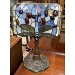 A Tiffany style lamp with a dragonfly decorated shade and base