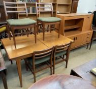 A mid 20th century teak dining suite comprising an extending dining table,