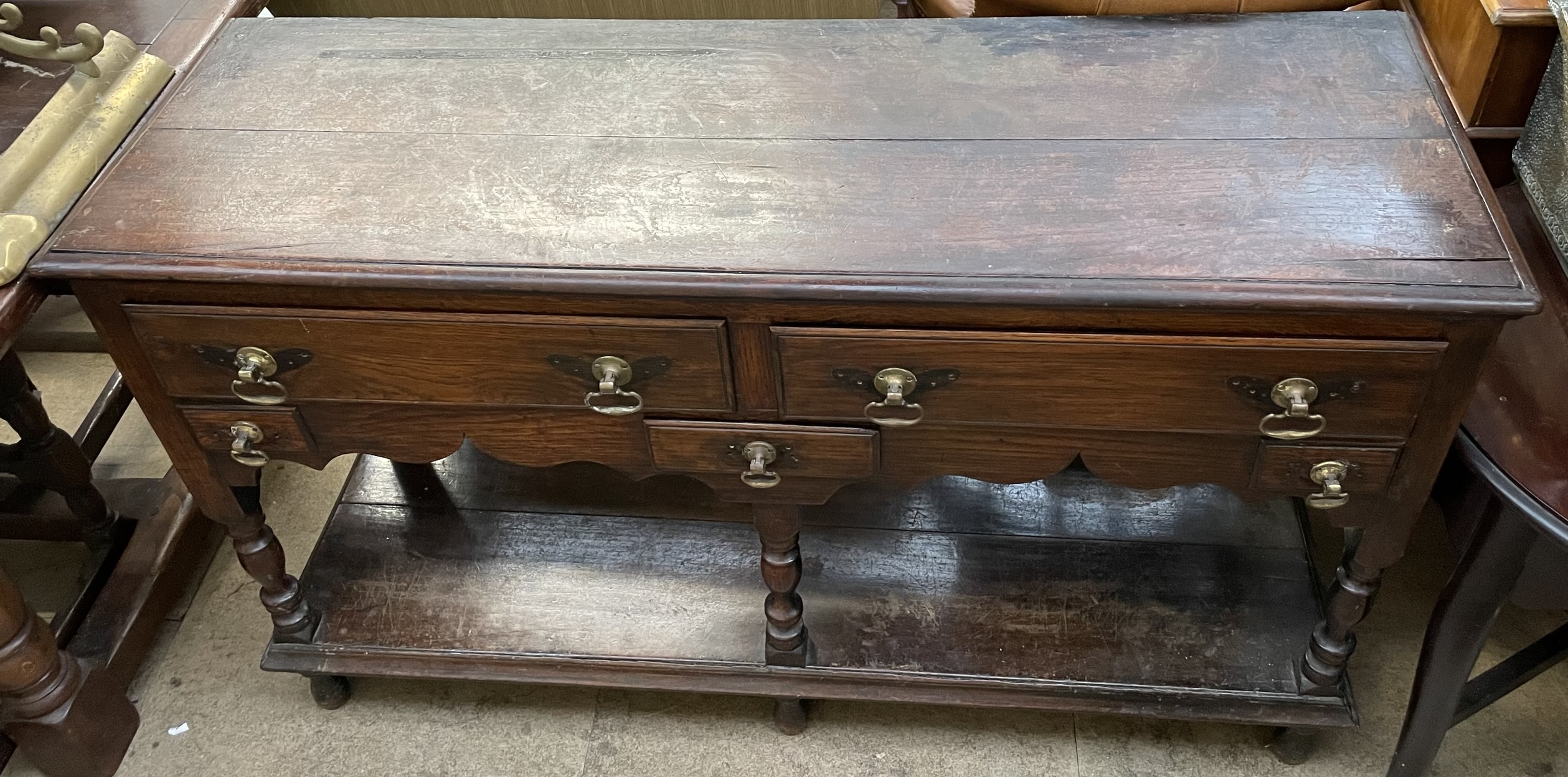 A 19th century oak dresser base with a planked rectangular top above five drawers and turned legs
