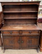 A 20th century oak kitchen dresser, with a moulded cornice and two shelves,