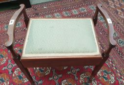 An Edwardian mahogany piano stool with a hinged pad seat on square tapering legs and spade feet