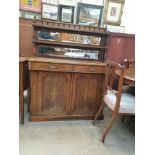 A Victorian walnut chiffonier with a spindle rail above two shelves and a mirrored back,