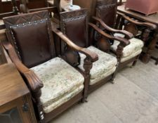 A set of three oak elbow chairs with an upholstered pad back on turned legs and brass casters