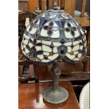 A Tiffany style table lamp with a domed shade in cream,