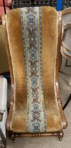A Victorian walnut framed nursing chair with beaded decoration and scrolling legs