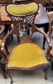 An Edwardian mahogany salon elbow chair with a pad and pierced back and seat on cabriole legs and