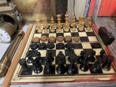 An ebonised and natural chess set, king 9cm high, pawn 4.