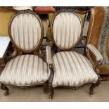 A pair of Victorian walnut framed chairs including a lady's and gentleman's chair with striped