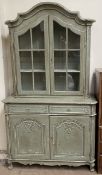 A continental painted bookcase with an arched top, glazed doors and sides,