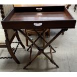 A mahogany butlers tray on a folding stand