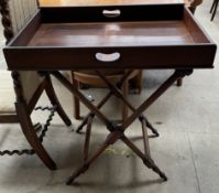 A mahogany butlers tray on a folding stand