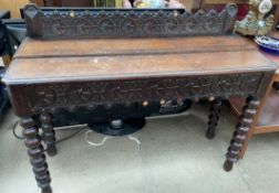 A 19th century oak side table with a carved back rail and similar frieze on bobbin turned legs