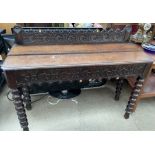 A 19th century oak side table with a carved back rail and similar frieze on bobbin turned legs