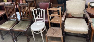 An oak elbow chair together with eight other chairs and a stool