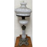 A Victorian oil lamp with an opaque glass shade and similar reservoir on a panelled baluster column