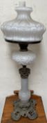 A Victorian oil lamp with an opaque glass shade and similar reservoir on a panelled baluster column