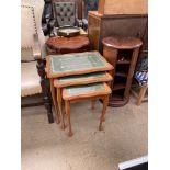 A 20th century nest of three tables with leather inset tops