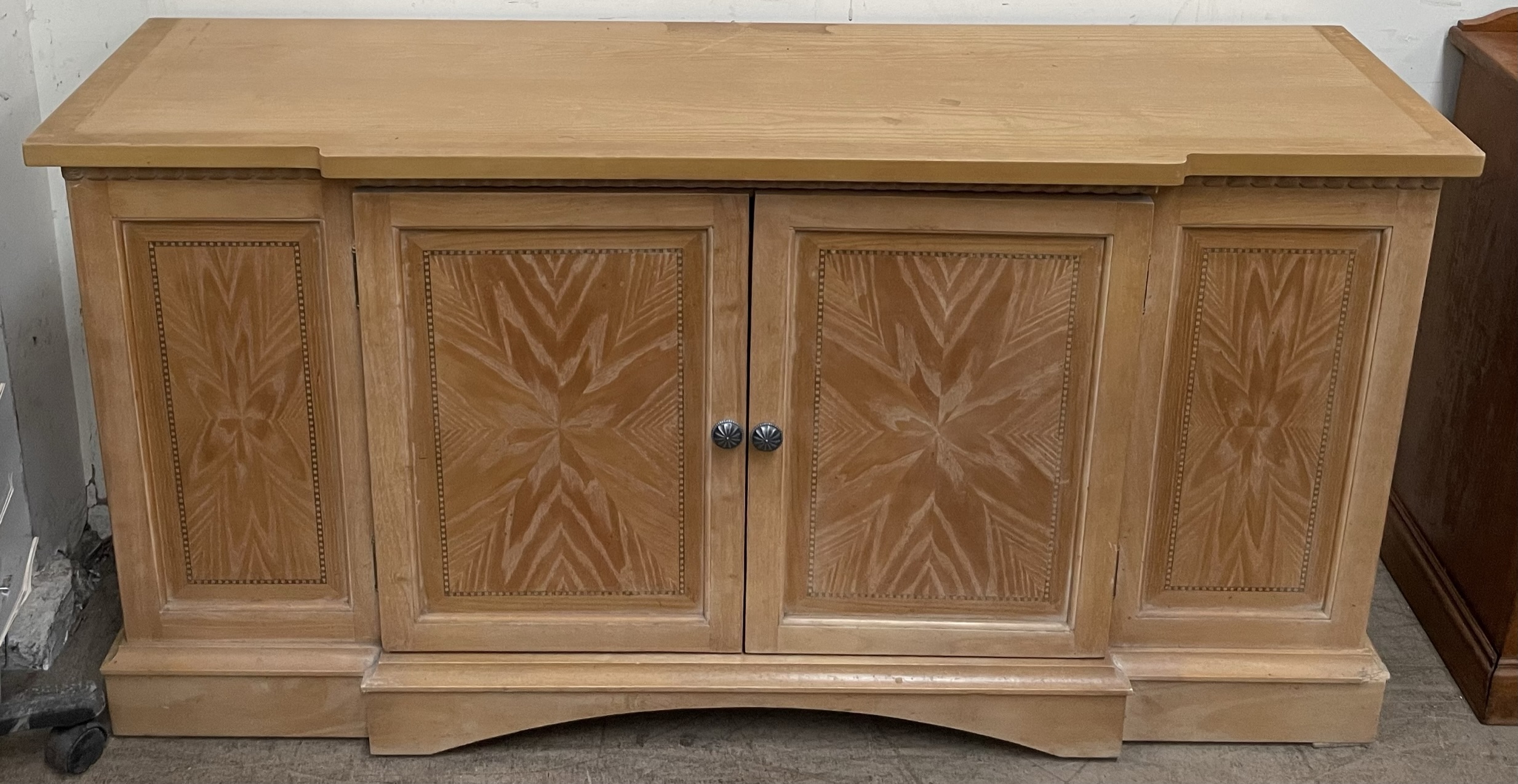 A 20th century sideboard with a pair of central cupboard doors on a plinth base