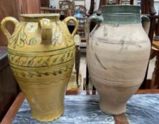 A studio pottery vase with four handles and a mustard yellow glaze and stylised flowers together