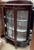 A 20th century mahogany display cabinet with a pair of doors on cabriole legs and claw and ball