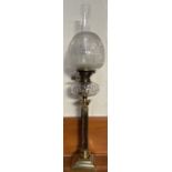 A brass and faceted clear glass oil lamp, with an etched glass shade,