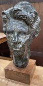 A bronzed portrait bust of a lady's head on a square plinth