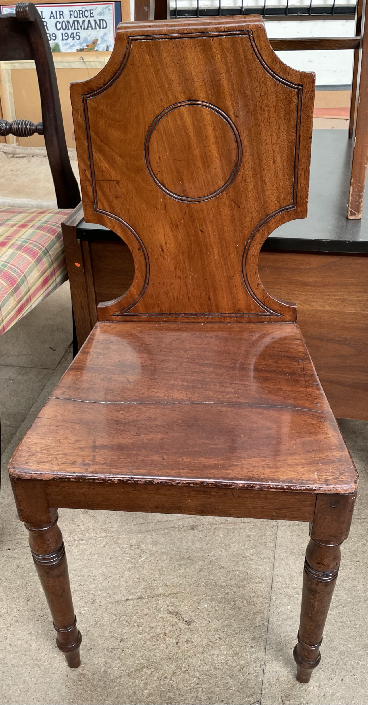 A Victorian mahogany hall chair with a shield shaped back on turned legs
