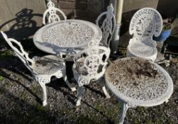 A white painted metal garden table and four chairs together with another chair and a coffee table