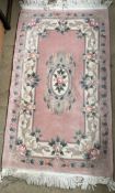 A pink ground Chinese rug together with a silk pile Kayam rug and two other Chinese rugs