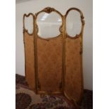 A French Gilt gesso three fold screen, carved with cherubs and leaves,