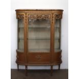 A continental gilt decorated display cabinet, with a D shaped top above a leaf moulded frieze,
