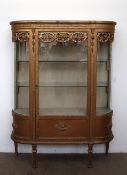 A continental gilt decorated display cabinet, with a D shaped top above a leaf moulded frieze,