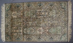 A Kashmir silk rug, with a green ground and multiple medallions, 126 x 76.