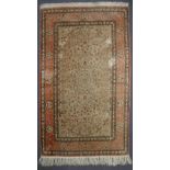 A silk rug, with a cream ground, and pink guard stripes, decorated with flowers,