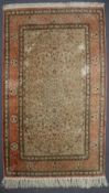A silk rug, with a cream ground, and pink guard stripes, decorated with flowers,