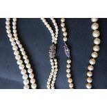 A double strand pearl necklace with graduated pearls, to a marcasite set clasp,