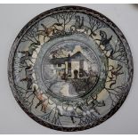 A stoneware plate, painted with Huntsman and hounds to the border, the centre with a village scene,