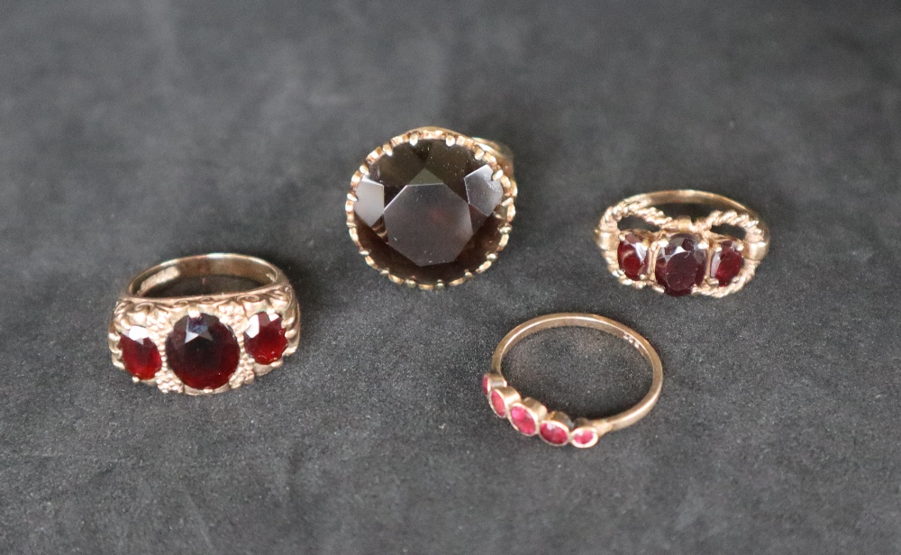 A 9ct gold ring set with three oval faceted garnets,