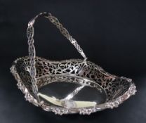 An Edward VII swing handled cake basket, of oval form with pierced decoration,